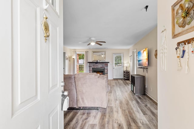 1646 S Jordan Dr, Clarksville, TN 37042 - foyer featuring light wood-type flooring, a ceiling fan, a stone fireplace, and baseboards