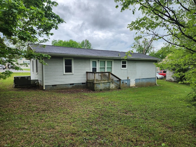 back of property featuring a yard, crawl space, and a shingled roof
