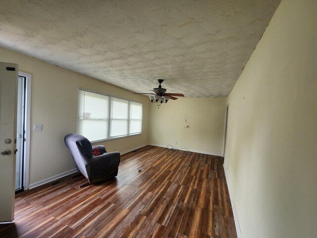 unfurnished room featuring ceiling fan, baseboards, dark wood-style flooring, and a textured ceiling