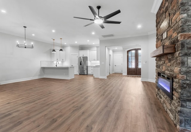 1048 Veridian Dr B, Clarksville, TN 37043 - unfurnished living room with a stone fireplace, visible vents, a sink, crown molding, and baseboards