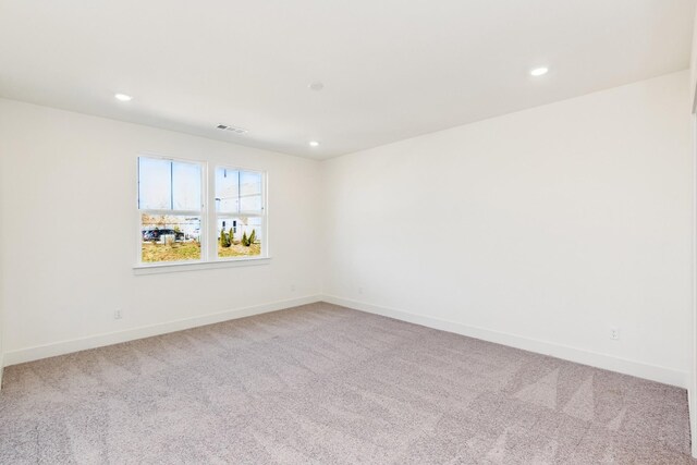 empty room with baseboards, recessed lighting, visible vents, and carpet