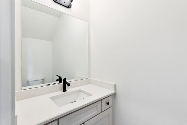 half bathroom with vanity and toilet