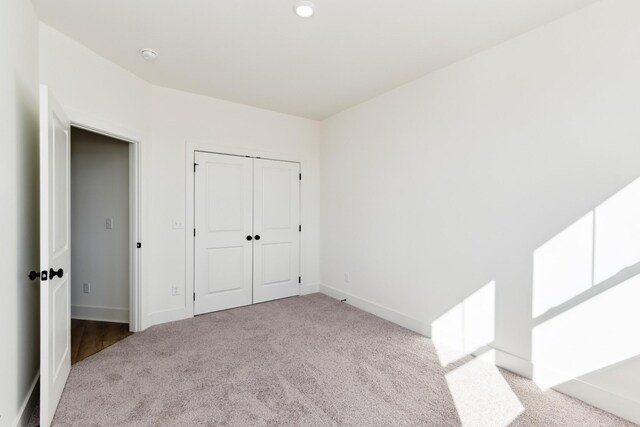 unfurnished bedroom featuring baseboards, a closet, and carpet
