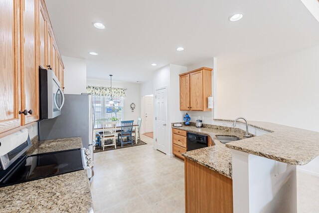 kitchen featuring a peninsula, light brown cabinetry, a sink, light stone countertops, and appliances with stainless steel finishes