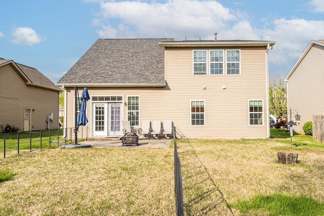 back of property with a fire pit, fence, a patio area, and a yard