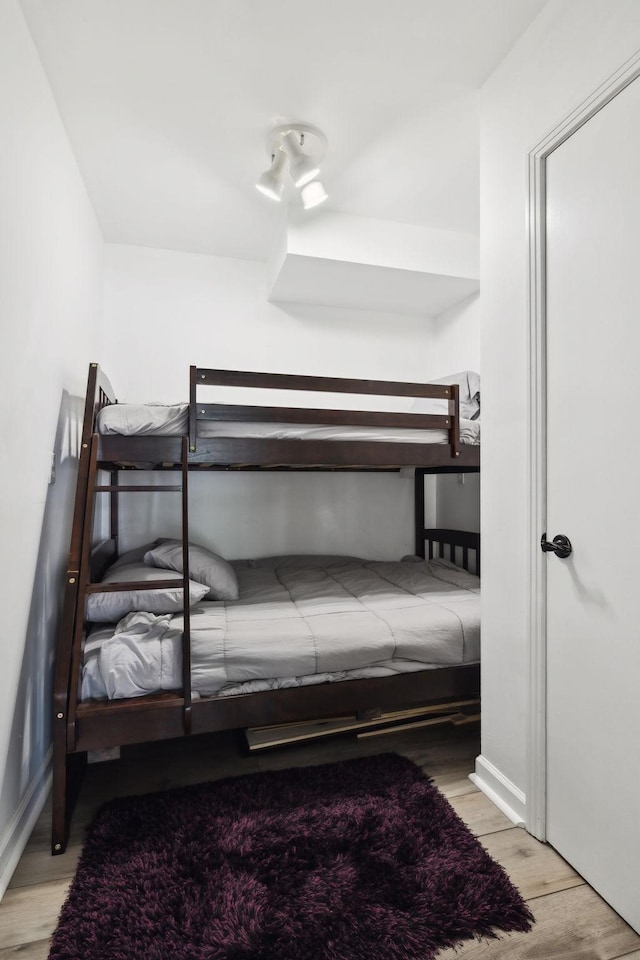 bedroom featuring baseboards and wood finished floors