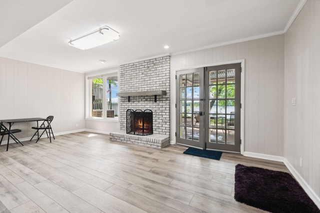 unfurnished living room with plenty of natural light, wood finished floors, a fireplace, and crown molding