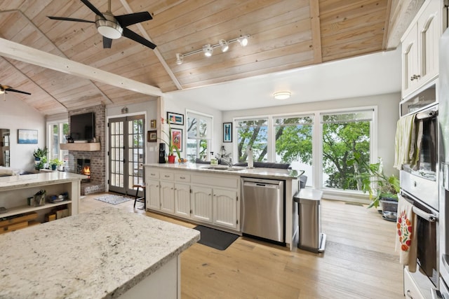kitchen featuring stainless steel appliances, open floor plan, ceiling fan, wood ceiling, and a fireplace