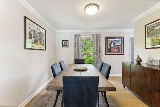 dining space featuring light wood-type flooring, baseboards, and ornamental molding
