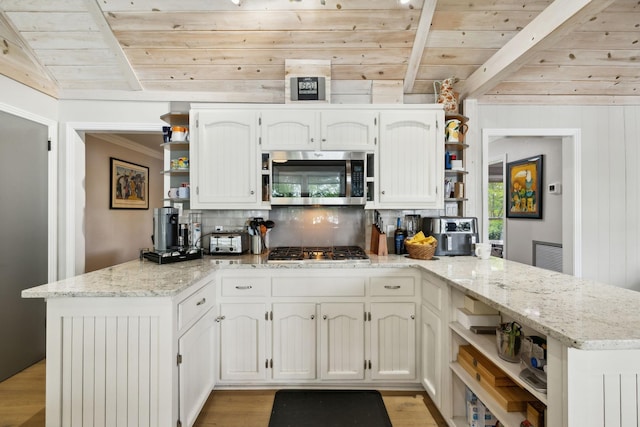 kitchen featuring a peninsula, open shelves, and stainless steel appliances