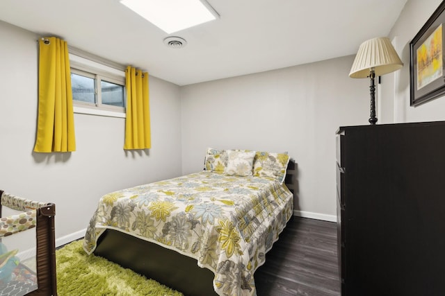 bedroom with baseboards, dark wood-style flooring, and visible vents