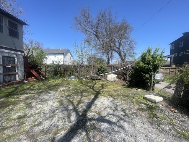 view of yard with stairs and a fenced backyard