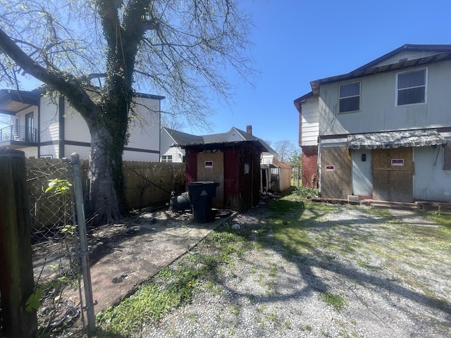 view of yard featuring an outdoor structure, fence, and a storage shed