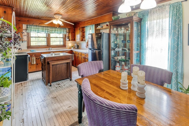 dining area with light wood-style flooring, a ceiling fan, and wood ceiling