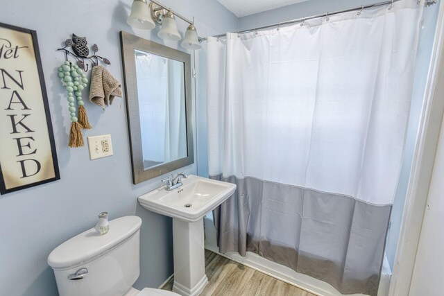 full bathroom featuring toilet, wood finished floors, and curtained shower