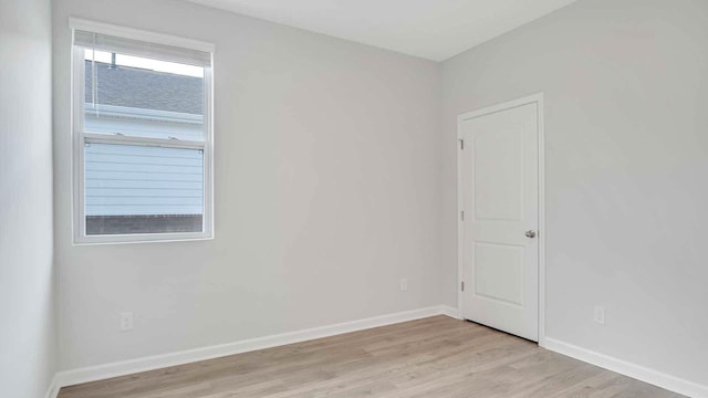 empty room featuring baseboards and light wood finished floors