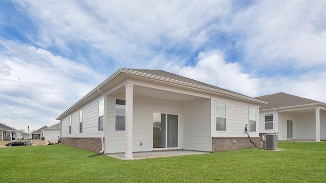 back of house featuring a lawn, central air condition unit, and a patio