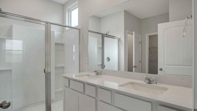 full bathroom featuring a sink, a walk in closet, and a stall shower