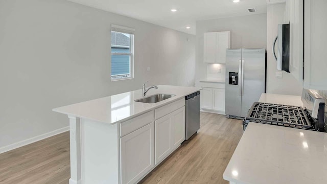 kitchen featuring a sink, white cabinetry, light wood-style floors, light countertops, and appliances with stainless steel finishes