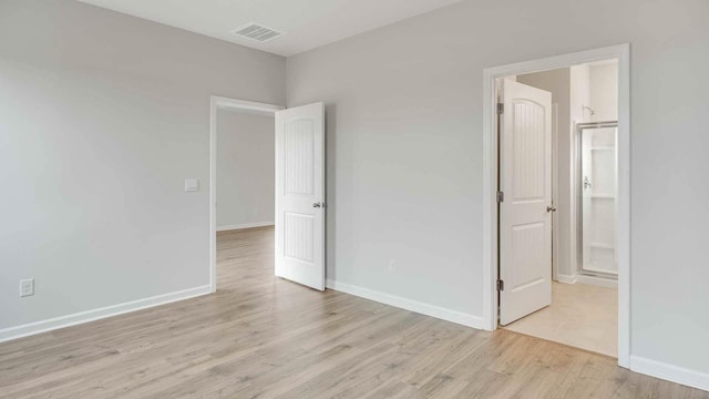 unfurnished bedroom with light wood-style floors, visible vents, and baseboards