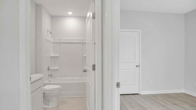 full bathroom with shower / washtub combination, wood finished floors, toilet, vanity, and baseboards