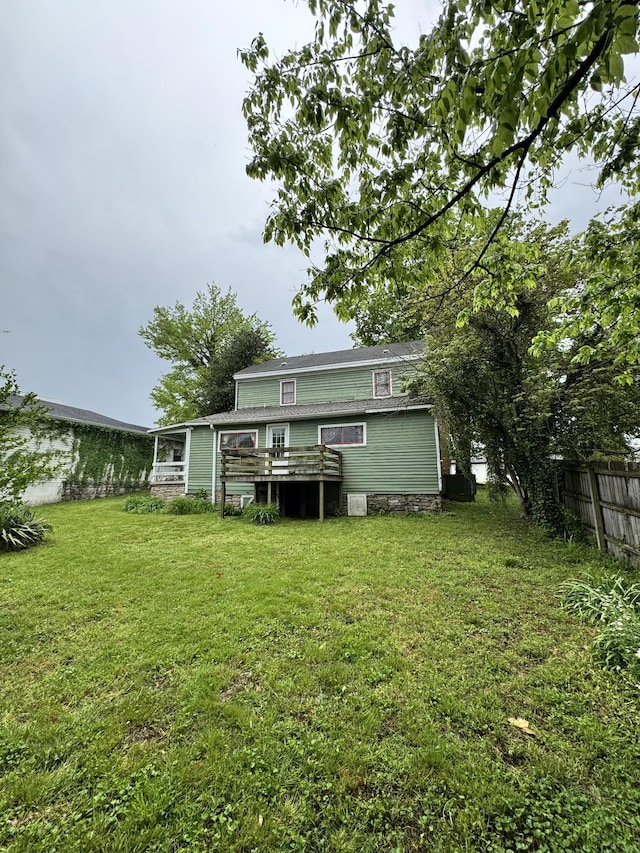 back of house featuring a yard, fence, and a deck