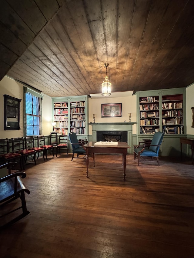 living area featuring wood ceiling, built in features, hardwood / wood-style floors, and a fireplace