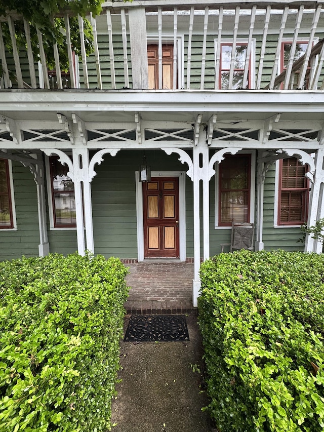 view of exterior entry featuring covered porch