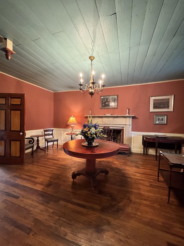dining space with a chandelier, wood finished floors, and wainscoting