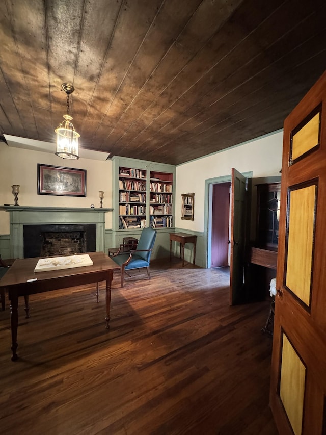 sitting room with wood finished floors, a fireplace, and built in shelves