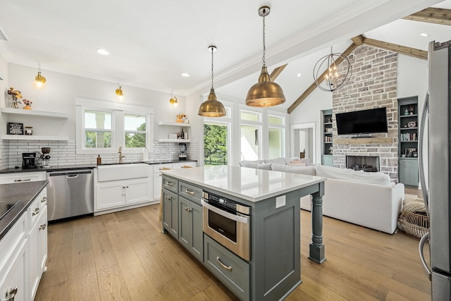 2040 Cairo Bend Rd, Lebanon, TN 37087 - kitchen with a large fireplace, a sink, stainless steel appliances, open shelves, and gray cabinetry