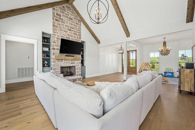 2040 Cairo Bend Rd, Lebanon, TN 37087 - living area with a chandelier, visible vents, beam ceiling, wood finished floors, and a stone fireplace