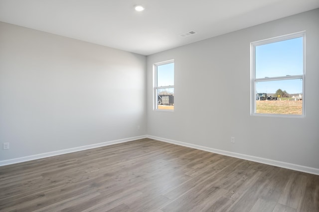 spare room featuring recessed lighting, wood finished floors, visible vents, and baseboards