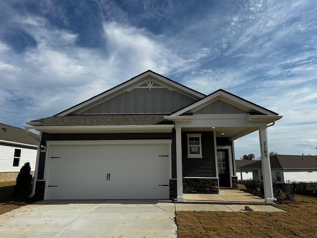 craftsman house featuring board and batten siding, a porch, a garage, and concrete driveway