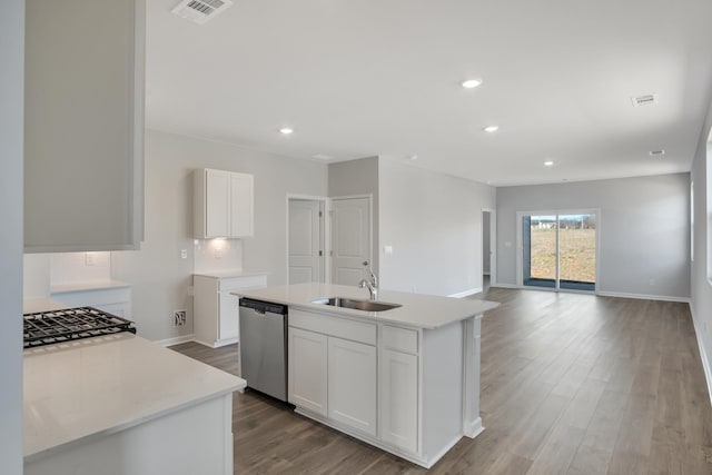 kitchen with light countertops, dishwasher, visible vents, a sink, and light wood-style floors