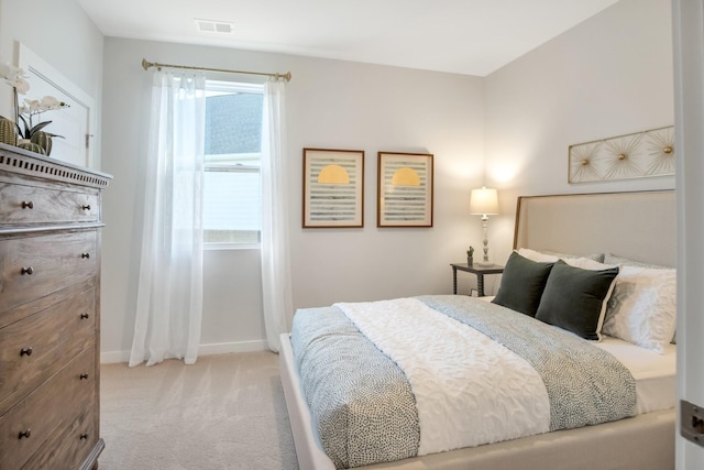 bedroom featuring baseboards, visible vents, and light colored carpet