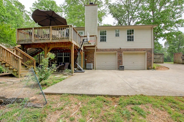 3473 Hunters Rdg, Woodlawn, TN 37191 - rear view of house with a chimney, central AC unit, concrete driveway, an attached garage, and stairs