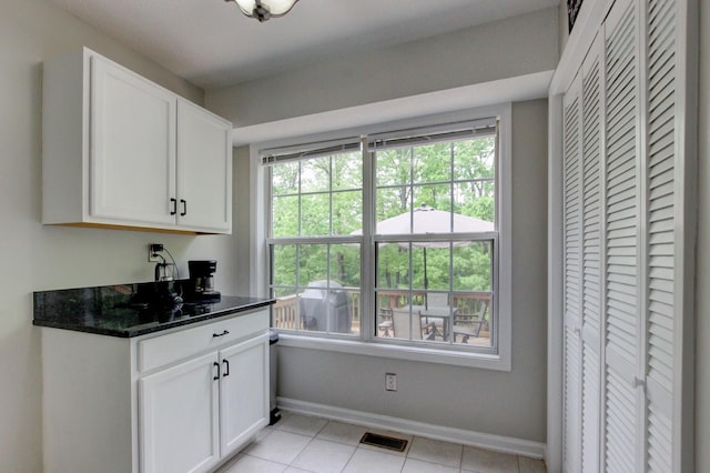 3473 Hunters Rdg, Woodlawn, TN 37191 - kitchen with visible vents, light tile patterned flooring, baseboards, white cabinets, and dark stone countertops