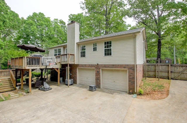 3473 Hunters Rdg, Woodlawn, TN 37191 - back of property with an attached garage, a deck, stairway, a chimney, and concrete driveway