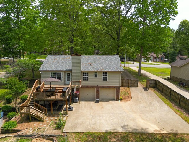 3473 Hunters Rdg, Woodlawn, TN 37191 - back of property featuring a deck, a chimney, concrete driveway, an attached garage, and stairway