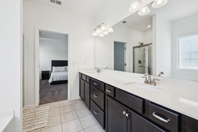 bathroom featuring a sink, a stall shower, double vanity, tile patterned flooring, and visible vents