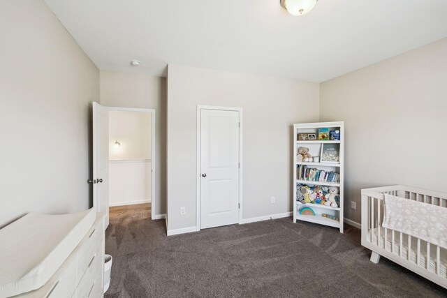 bedroom featuring dark carpet and baseboards