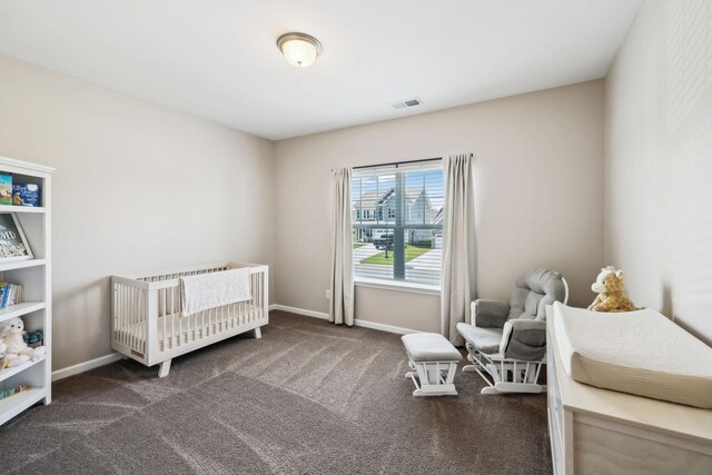 carpeted bedroom with baseboards, a crib, and visible vents