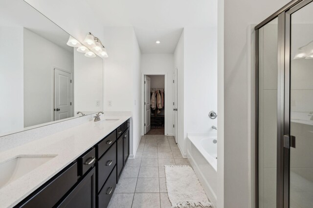 full bathroom with tile patterned floors, a sink, double vanity, a shower stall, and a garden tub