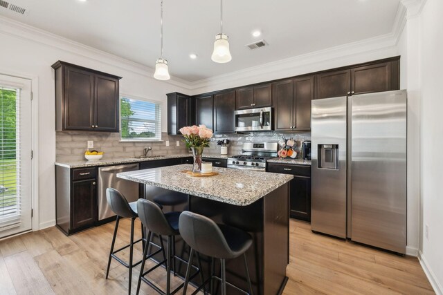 kitchen featuring dark brown cabinets, visible vents, backsplash, and appliances with stainless steel finishes