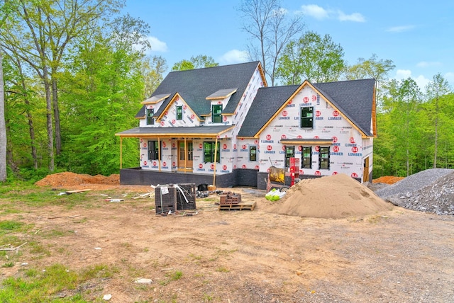 rear view of property with roof with shingles and a porch