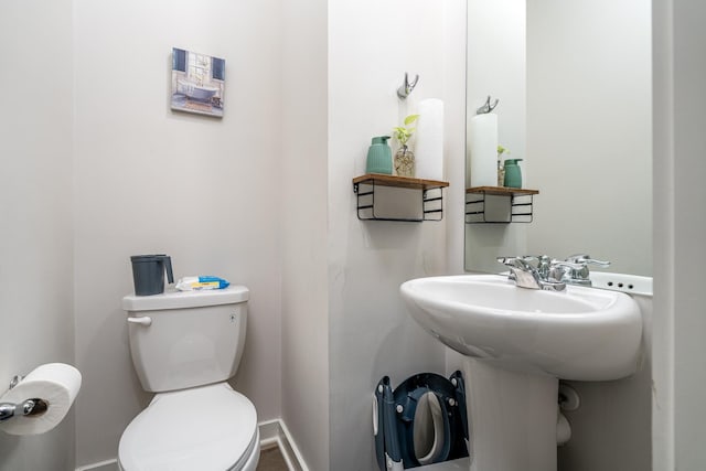 half bathroom with toilet and baseboards