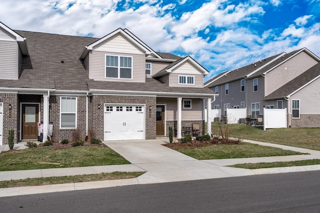 craftsman house with brick siding, driveway, and a front yard