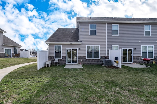 rear view of house with a lawn, brick siding, and a patio