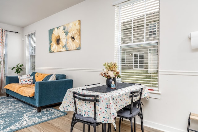 dining space featuring baseboards and wood finished floors